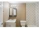 Bathroom featuring white tile shower surround, white vanity, and a framed mirror at 1106 N Sheffield Ave, Indianapolis, IN 46222