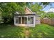 Exterior shot of sunroom addition, showing backyard, and the house blending with mature trees at 1106 N Sheffield Ave, Indianapolis, IN 46222
