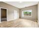 Bright living room with hardwood floors, neutral paint, and a large window offering natural light at 1106 N Sheffield Ave, Indianapolis, IN 46222