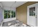 Enclosed sunroom with access to the backyard and featuring a white door and multiple windows at 1106 N Sheffield Ave, Indianapolis, IN 46222