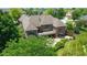 Stunning aerial view of a brick home featuring a large deck and patio surrounded by lush landscaping and mature trees at 11761 Darsley Dr, Fishers, IN 46037