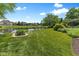 Scenic backyard featuring lush green lawn, landscaping, and a serene pond, perfect for relaxation and outdoor activities at 11761 Darsley Dr, Fishers, IN 46037