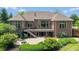 Backyard features home with a patio, deck, fire pit, lush green lawn, and thoughtfully designed landscaping at 11761 Darsley Dr, Fishers, IN 46037