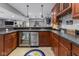 Finished basement bar area featuring custom cabinetry, stainless steel beverage refrigerator, and stone tile flooring at 11761 Darsley Dr, Fishers, IN 46037