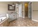En-suite bathroom boasts double vanity, chandelier, shower, and garden tub at 11761 Darsley Dr, Fishers, IN 46037