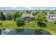 Beautiful brick home featuring a backyard pond and a deck, surrounded by mature trees and lush greenery at 11761 Darsley Dr, Fishers, IN 46037