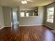 Open-concept living area featuring wood floors, light-colored walls, and a view into the kitchen at 12307 Chiseled Stone Dr, Fishers, IN 46037