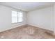 A carpeted bedroom with a window allowing natural light and white walls, creating a bright, minimalist space at 12820 Gloria Dr, Fishers, IN 46037