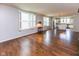 Open living room with large windows, hardwood floors, and a seamless flow to the dining area and kitchen at 12820 Gloria Dr, Fishers, IN 46037