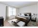 A well-appointed primary bedroom features a bed, bench, stylish decor and ample natural light at 12820 Gloria Dr, Fishers, IN 46037