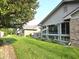 A view of the rear exterior showing well maintained lawn and sunroom at 1311 Aaron Dr, Shelbyville, IN 46176
