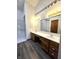 Bathroom featuring double sink vanity, walk-in shower and wood-look flooring at 1311 Aaron Dr, Shelbyville, IN 46176