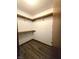 Walk-in closet with wood-look flooring and wood shelf with silver supports at 1311 Aaron Dr, Shelbyville, IN 46176