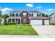 Inviting two-story home boasting a manicured lawn, three-car garage and brick and siding facade with classic shutters at 1343 Turfway Dr, Avon, IN 46123