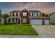Inviting two-story home boasting a manicured lawn, three-car garage and brick and siding facade with classic shutters at 1343 Turfway Dr, Avon, IN 46123