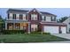Two-story brick home boasting a well-manicured lawn, attached two-car garage, and classic black shutters at 1343 Turfway Dr, Avon, IN 46123