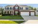 Charming two-story brick home featuring a two-car garage, manicured lawn, and classic black shutters at 1343 Turfway Dr, Avon, IN 46123
