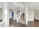 Open foyer featuring a staircase with white railings and dark wood floors throughout the main level at 1343 Turfway Dr, Avon, IN 46123