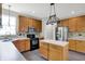 Kitchen with island, wood cabinets, stainless steel refrigerator, and pendant lighting at 1343 Turfway Dr, Avon, IN 46123