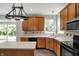 Kitchen with island, wood cabinets, black appliances, and pendant lighting at 1343 Turfway Dr, Avon, IN 46123