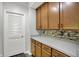 Walk-in pantry with wooden cabinets, gray countertops and white, louvered door at 1343 Turfway Dr, Avon, IN 46123