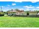 Backyard view of the home and shed, with a picket fence and green lawn at 1411 N Kenmore Rd, Indianapolis, IN 46219