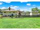 Well-kept backyard with a wooden fence, detached garages, and a lush lawn, ideal for outdoor activities at 1411 N Kenmore Rd, Indianapolis, IN 46219
