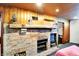 Basement with a brick fireplace, wood paneling, and rustic decor for a cozy, inviting space at 1411 N Kenmore Rd, Indianapolis, IN 46219