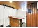 Basement featuring a wooden bar area and rustic wood-paneled door, creating a unique space at 1411 N Kenmore Rd, Indianapolis, IN 46219