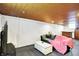 This finished basement features a wooden ceiling, a comfortable sofa, and space for entertaining at 1411 N Kenmore Rd, Indianapolis, IN 46219