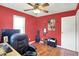 Bedroom featuring red walls, hardwood floor, guitars, and an amp for music enthusiasts at 1411 N Kenmore Rd, Indianapolis, IN 46219