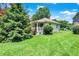 Well-kept home showcasing a verdant lawn, mature trees, and a charming porch at 1411 N Kenmore Rd, Indianapolis, IN 46219