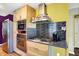 This kitchen features stainless steel appliances and range hood, and abundant wood cabinets at 1411 N Kenmore Rd, Indianapolis, IN 46219
