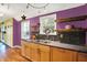Charming kitchen featuring stainless steel sink, granite countertops, wood cabinets, and rustic wood shelving at 1411 N Kenmore Rd, Indianapolis, IN 46219
