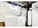 Bright laundry room featuring a washer, dryer and a water heater at 1411 N Kenmore Rd, Indianapolis, IN 46219