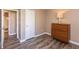 Well-lit bedroom with wood-look flooring and a dresser with a lamp at 1450 Millridge Dr, Greenwood, IN 46143
