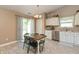 Eat-in kitchen with white cabinetry, stainless steel appliances, a dining table, and sliding door access to the backyard at 1450 Millridge Dr, Greenwood, IN 46143