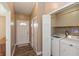 Laundry area featuring a washer and dryer, storage shelves, and access to the entryway at 1450 Millridge Dr, Greenwood, IN 46143