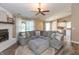 Open-concept living room showcasing a fireplace, ceiling fan, and a comfortable sectional sofa with decorative pillows at 1450 Millridge Dr, Greenwood, IN 46143