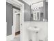 Gray and white bathroom with pedestal sink, white wainscoting, and updated fixtures at 1511 E Edwards Ave, Indianapolis, IN 46227