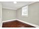 Bright bedroom with wood floors, gray walls, and a large window at 1511 E Edwards Ave, Indianapolis, IN 46227