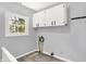 Functional laundry area with storage cabinets, window, and essential utility connections at 1511 E Edwards Ave, Indianapolis, IN 46227