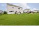 Expansive backyard view showcasing a well-manicured lawn, play area, and a black perimeter fence at 15598 Memorial Way, Fishers, IN 46037