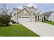 Inviting two-story home with a spacious driveway leading to a two-car garage and charming front yard at 15598 Memorial Way, Fishers, IN 46037