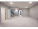Well-lit basement with carpeted floor, access to the stairs, and white paneled door at 1590 Birchfield Dr, Westfield, IN 46074