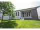 Exterior view of a home featuring a covered patio with a brick fireplace, a manicured lawn, and mature trees at 1590 Birchfield Dr, Westfield, IN 46074