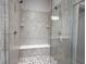 Close up of the elegant shower with double shower heads, gray tiles, and a built-in bench at 1590 Birchfield Dr, Westfield, IN 46074