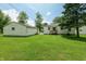 Spacious backyard with a detached garage and mature trees providing shade at 1727 S Irvington Ave, Indianapolis, IN 46203