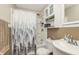 Well-lit bathroom with tub, shower, patterned shower curtain, vanity and medicine cabinet at 1727 S Irvington Ave, Indianapolis, IN 46203
