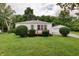Quaint single-story home with a well-maintained lawn, mature trees, and a detached garage at 1727 S Irvington Ave, Indianapolis, IN 46203